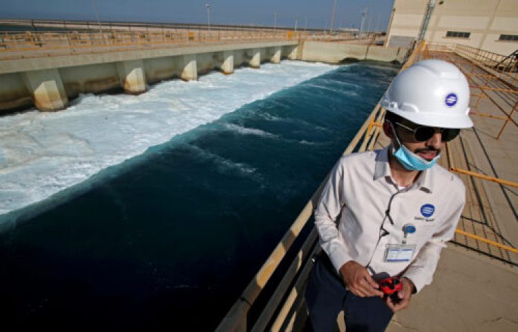 An employee stands next to a waste water collection pool at the Saline Water Conversion Corporation's Ras Al-Khair Power and Desalination Plant, the world's largest desalination plant using modern hybrid desalination technology, at Ras Al-Khair, Saudi Arabia, October 8, 2020. Picture taken October 8, 2020. REUTERS/Hamad I Mohammed